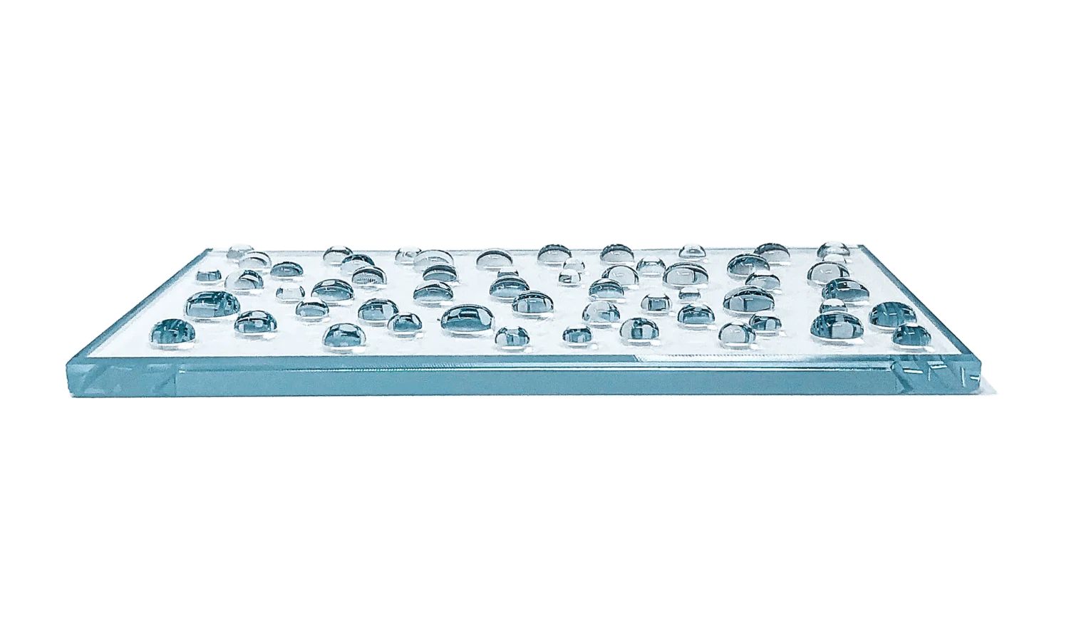 Transparent rectangular tray holding dozens of glass marbles arranged in rows.
